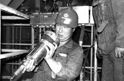 圖為尤天軍在檢修設備。資料照片